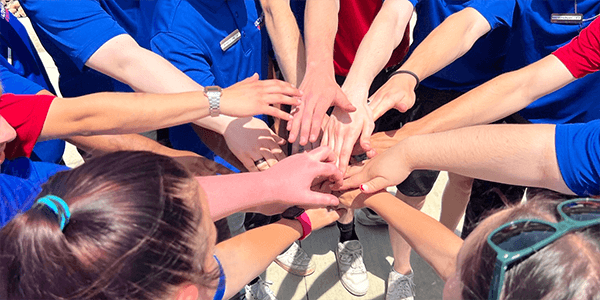 Team of employees with their hands in a circle